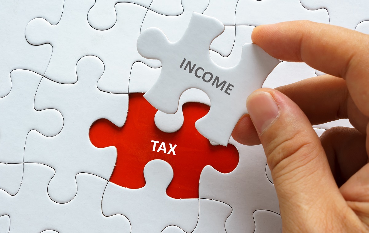 Slika prikazuje belo puzlo, nakateri piše INCOME in rdečo, na kateri piše TAX.