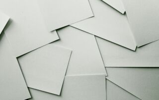 Slika prikazuje bele prazne liste raztrošene po mizi.