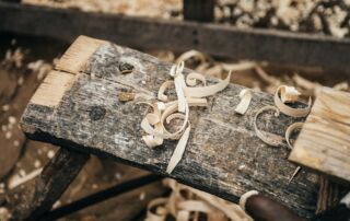 Slika prikazuje delovno mizo tesarja, na katerem so ostružki lesa.