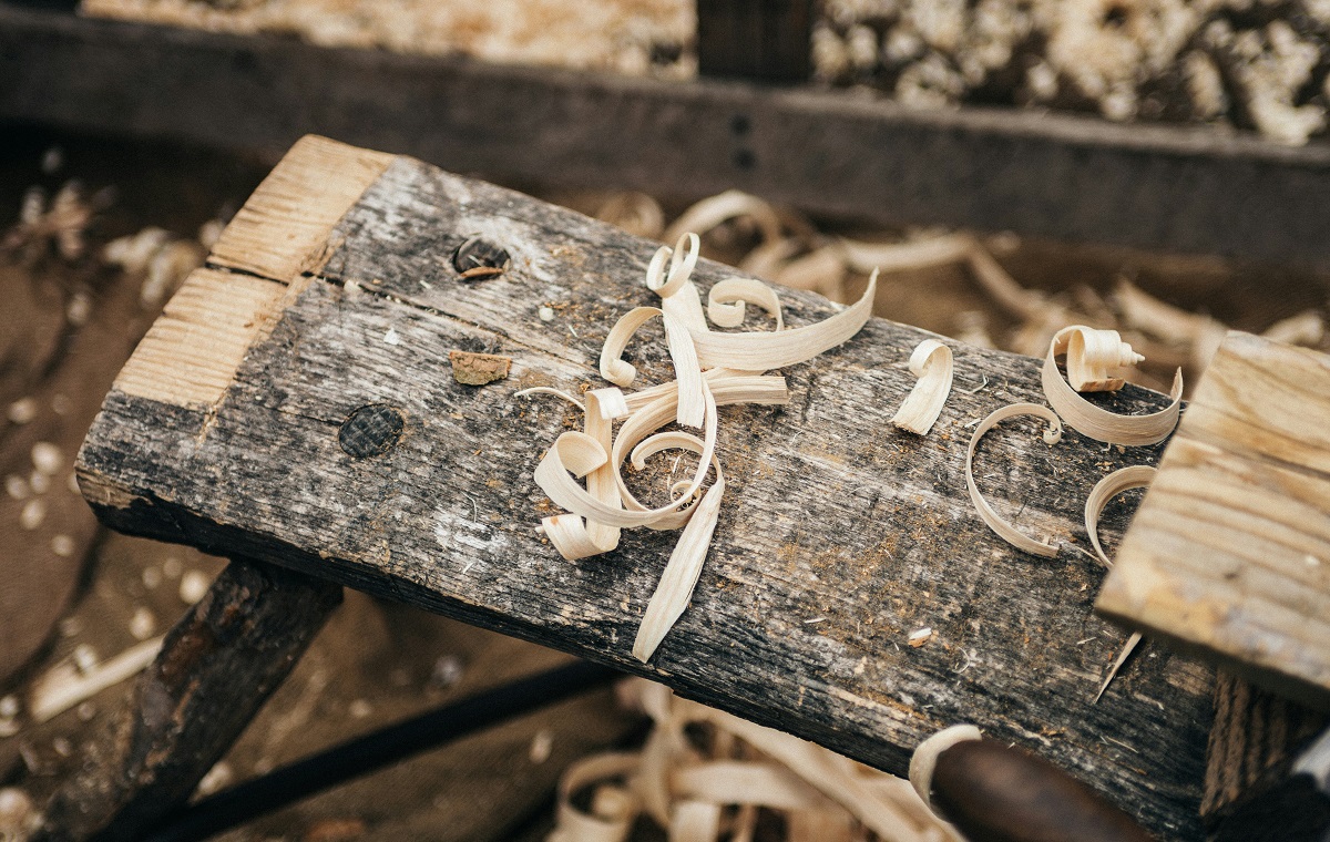 Slika prikazuje delovno mizo tesarja, na katerem so ostružki lesa.