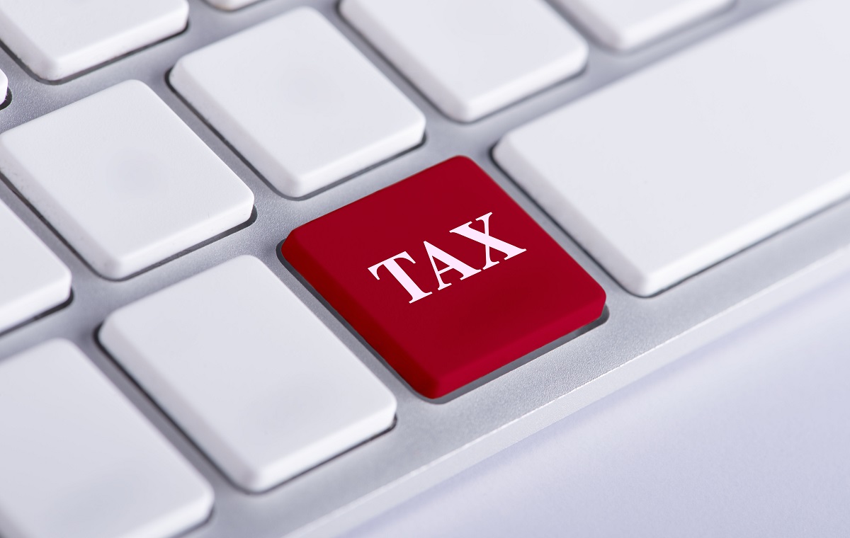 Slika prikazuje belo tipkovnico računalnika z eno rdečo tipko, na kateri je beseda TAX.