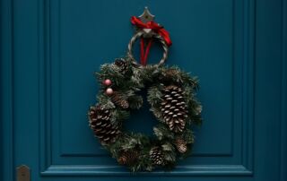 Modra vhodna vrata, na katerih vidi božični venček.