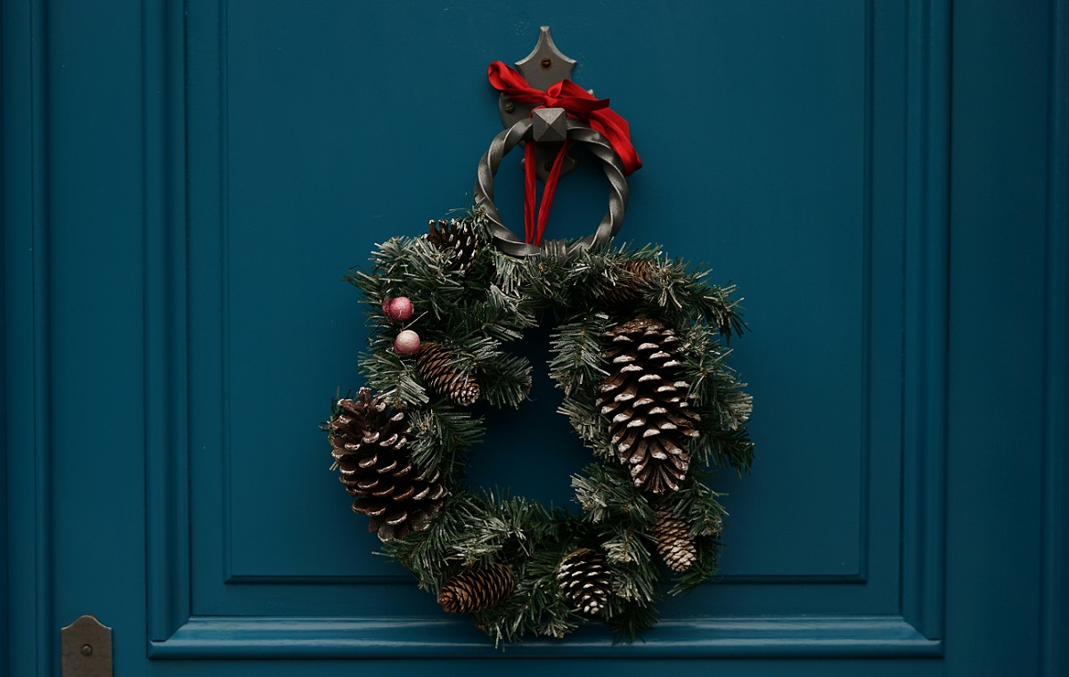 Modra vhodna vrata, na katerih vidi božični venček.